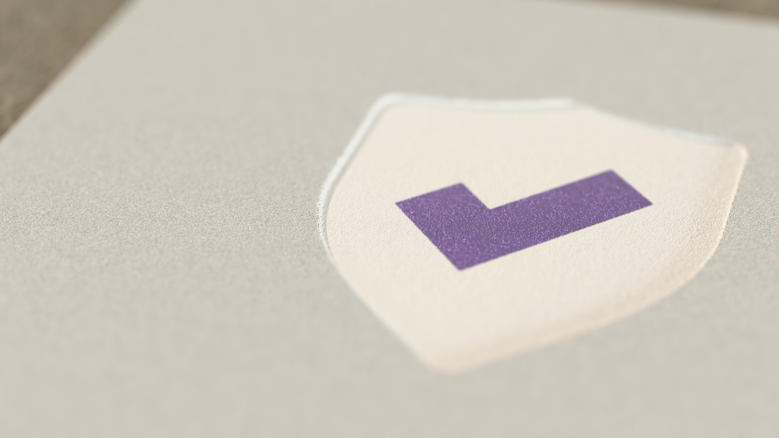 The DocHelp crest, a shield with a tick, pressed into thick cotton paper, the tick in plum foil